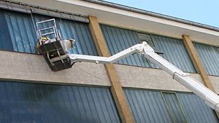 Arbeiter in Krankabine reinigt eine Fassade